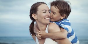 Portrait of happy mother and son at sea