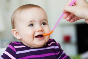 Baby Sitting in Chair Being Fed --- Image by © Emely/cultura/Corbis