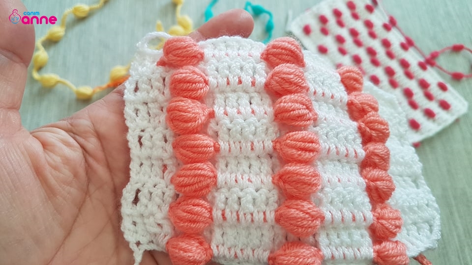 The pattern of a baby blanket with a crochet pompon